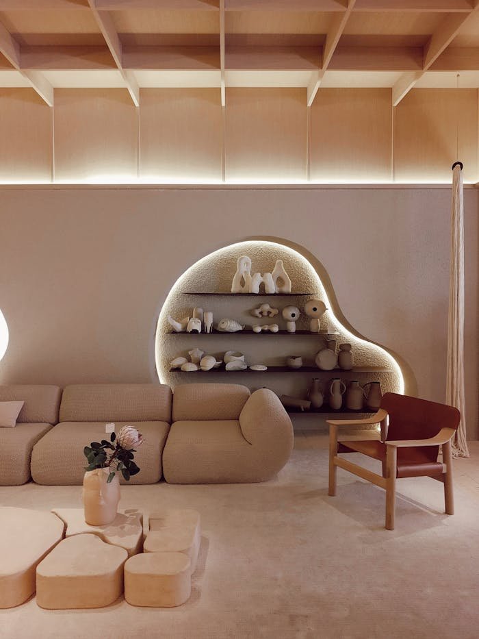 A beige modern living room with minimal decor and creative lighting, located in SP, Brazil.
